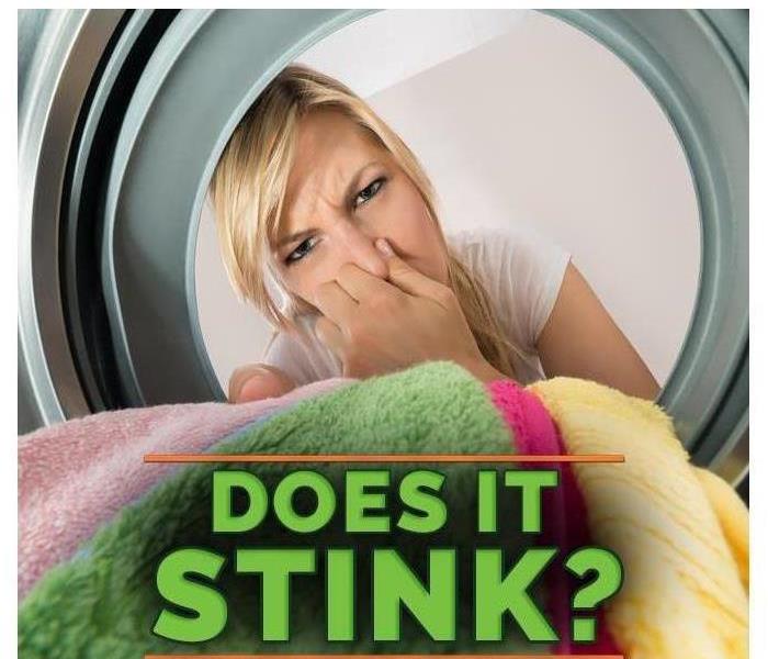 Woman covering her nose due to bad odor in washing machine